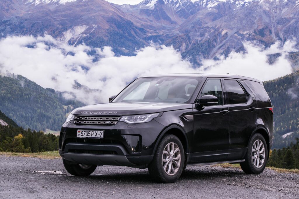 Black Jaguar Land Rover Discovery parked in countryside hills